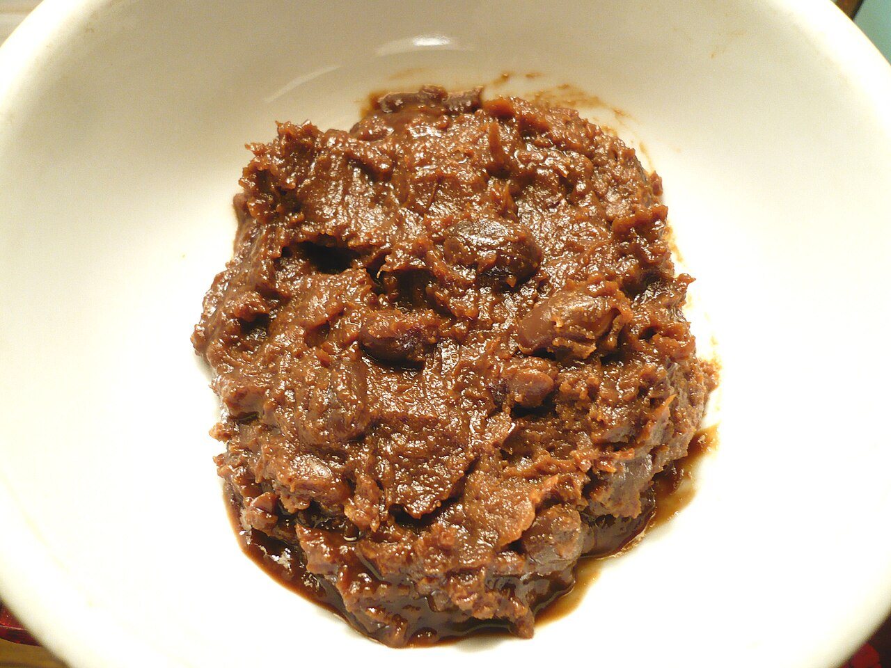 A small bowl of doenjang with whole soybeans